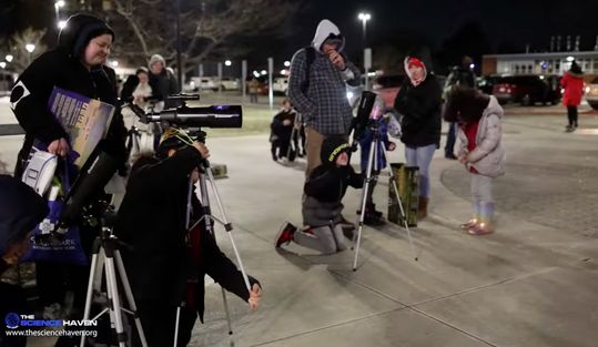 Families observe the sky together outside the planetarium